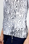 Top Ligne Squiggles Grommets Top in Black & White. Op art squiggle print in black on a white background. V neck 3/4 sleeve top with grommets and lace-up detail at left front hem. Relaxed fit._t_35010878275784