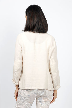 Organic Rags Fringed Linen Jacket in Taupe. Open front banded collar jacket. Long sleeves with elbow patch detail. Faux front flap pockets. Contour seams. Fringed edges at collar and hem._34995340148936