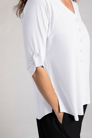 Sympli Convoy Henley in White. V neck with 5 button placket. 3/4 sleeve with button tab closure in satin crepe. Back yoke with inverted pleat below. Curved hem. Side slits. Relaxed fit._35065503154376
