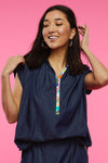 Zaket & Plover Confetti Blouse in Denim with bright multi print. Mixed media, henley-style top. Pointed collar with printed 6 button placket. Banded cap sleeve. Back yoke in denim with printed fabric below. Shirt tail hem. Relaxed fit._t_34998176940232