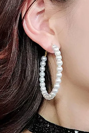 The Pearly Hoop Earrings are classic and chic hoop earrings each featuring 23 luminous imitation pearl beads on a golden wire hoop secured by a standard hypoallergenic earring post and hinged clasp._33085569827016