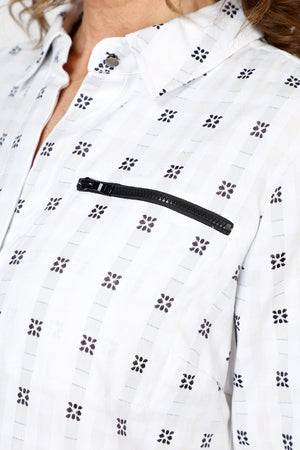 Cali Girls Betty Check Embroidered Blouse in White/Black.  Gingham check with contrast color embroidery.  Pointed collar button down blouse with hidden button placket.  3/4 sleeve with fold back cuff and button detail.  Coral zipper detail above left breast.  Back yoke with ring tab and inverted back pleat.  Relaxed fit._59841889337710