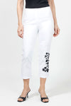Holland Ave Embroidered Denim Crop in White with black floral embroidery on lower left leg.  Hidden elastic waistband, faux fly pull on pant.  2 back rounded patch pockets.  Snug through stomach and hip.  Tapered to hem.  1/2" cuff. 26" inseam._t_34980855185608