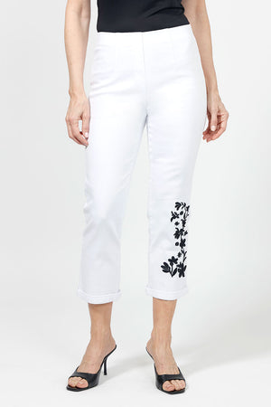 Holland Ave Embroidered Denim Crop in White with black floral embroidery on lower left leg.  Hidden elastic waistband, faux fly pull on pant.  2 back rounded patch pockets.  Snug through stomach and hip.  Tapered to hem.  1/2" cuff. 26" inseam._34980855185608