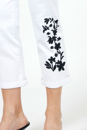 Holland Ave Embroidered Denim Crop in White with black floral embroidery on lower left leg. Hidden elastic waistband, faux fly pull on pant. 2 back rounded patch pockets. Snug through stomach and hip. Tapered to hem. 1/2" cuff. 25 1/2" inseam._34980855120072
