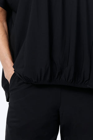 O.U.R.S. Stacey Ruched Front Top in Black. Crew neck dolman short sleeve top. Center front inset panel is softly gathered at the neckline and ruched at the hem. Inverted "U-shaped" hem. Plain back. Relaxed fit._34815862407368