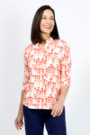 Lolo Luxe Trish Paper Dots Top in Coral. Abstract gradient dots on a white background. Banded collar split v neck top with 3/4 sleeve with banded cuff. Curved hem. Relaxed fit._t_34940477309128