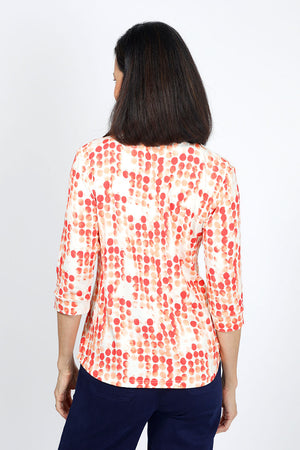 Lolo Luxe Trish Paper Dots Top in Coral. Abstract gradient dots on a white background. Banded collar split v neck top with 3/4 sleeve with banded cuff. Curved hem. Relaxed fit._34940477178056
