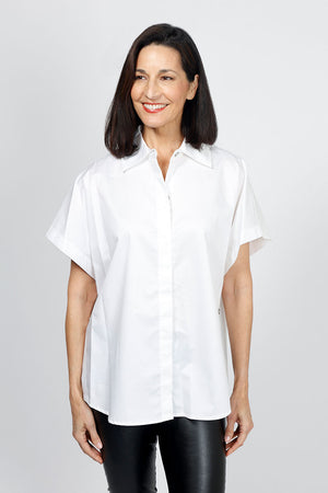 Planet Button Up Shirt in White. Pointed collar button down with hidden button placket. Short dolman sleeve. 3 functional buttons at side seams. Curved hem in front. One size fits many_34953303228616