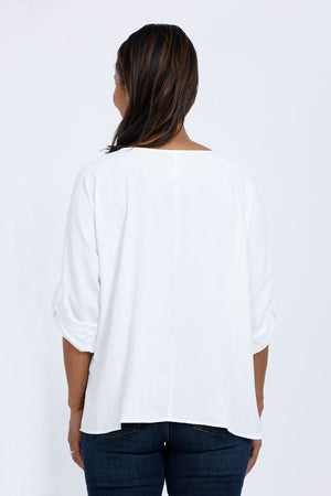 Top Ligne Dolman Roll Tab Top in White. Gently crinkled fabric. V neck with center front pleat. Dolman 3/4 sleeve with roll button tab cuff. A line shape. Relaxed fit._34767644033224