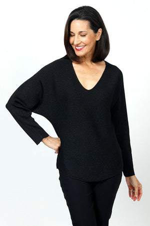 Ten Oh 8 Metallic V Neck Dolman in Black. V neck long sleeve dolman sleeve knit. Knit side to side to create ribbing. Rib trim at neck hem and cuff. Lurex thread adds metallic glow. Relaxed fit._34654382653640