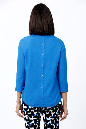 Ten Oh 8 Button Back Sweater in Ocean blue. Crew neck 3/4 sleeve horizontal textural rib. Curved hem. Braid trim at neck, hem and cuff. Button detail down center back. Relaxed fit._34826715070664