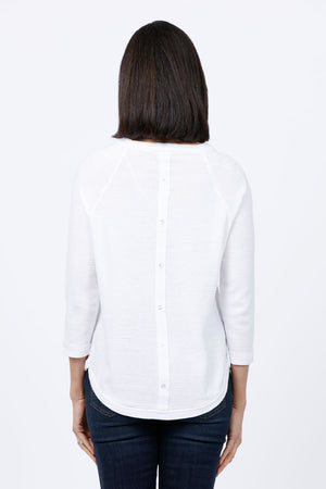 Ten Oh 8 Button Back Sweater in White. Crew neck 3/4 sleeve horizontal textural rib. Curved hem. Braid trim at neck, hem and cuff. Button detail down center back. Relaxed fit._34826715103432