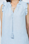 Organic Rags Washable Linen Striped Ruffle Trim Top in Denim and white stripes. V neck with ruffle collar and attached tassel ties. Sleeveless with ruffle trim. A line shape. Side slits. Relaxed fit._t_35181654442184