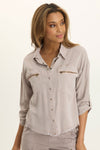 Wearables Knapp Twill Utility Snap Front Blouse in Foxglove.  Pointed collar snap front shirt.  3/4 sleeve with snap tab.  2 front zip breast pockets.  Back yoke in slub jersey.  Slub jersey insets at underarm.  Curved hem.  Fringed hem. Classic fit._t_61444814733678