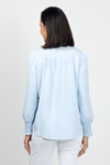 Beau Chemise Ruched Sleeve Popover in Sky. Banded crew neck with ruffle trim. Hidden 1/4 zipper front closure. Long sleeves with smocked cuff. Back yoke with soft gathers below. Shirt tail hem. Relaxed fit._t_35036162293960