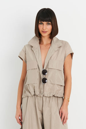 Planet Mini Cargo Vest in Fawn. Pointed collar button down cropped vest with covered button placket. 2 front lap large cargo pockets. Elastic cinching at hem. One size fits many._34923728699592