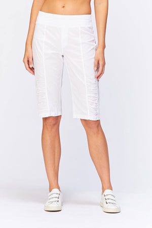 Wearables Tatem Bermuda in White. 2 1/2" elastic jersey waistband. Poplin body. Front center seams with ruch detail at sides. Curved back yoke. 10" rise in front; 15 1/2"in back. 14 1/2" inseam._34980809933000