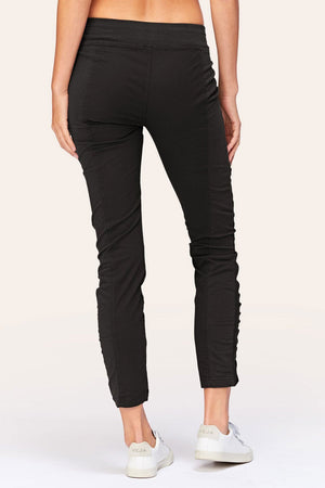 Wearables Malanda Pant in Black.  Pull on pant with 2 1/2" jersey elastic waistband.  Poplin body.  2 front slash pockets.  1 single zip front pocket.  Contour seams.  Ruched detail on front leg.  Jersey insets at side.  28" inseam. _61269626356078