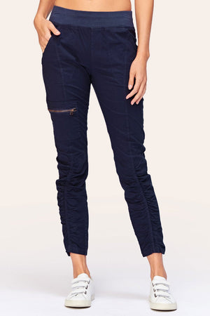 Wearables Malanda Pant in Navy.  Pull on pant with 2 1/2" jersey elastic waistband.  Poplin body.  2 front slash pockets.  1 single zip front pocket.  Contour seams.  Ruched detail on front leg.  Jersey insets at side.  28" inseam. _61269626487150