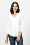 Sno Skins Dream V Neck Top in White. Textured swirl tone on tone print. V neck top with 3/4 bell sleeve. Curved hem. Relaxed fit._t_34622208639176