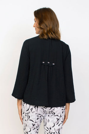 Habitat Travel Pleat Back Jacket in Black.   Spread collar button down with matching novelty buttons.  2 front angled pockets with flap detail.  3/4 sleeve. Back yoke with 3 button tab detail.  High low hem.  A line shape. Relaxed fit._35123615858888