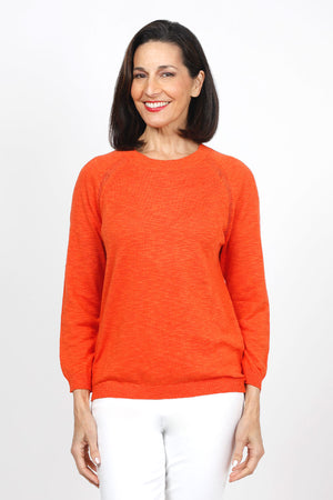 Metric Pointelle Crew Neck Sweater in Orange. Crew neck long sleeve sweater with raglan sleeves. Pointelle stitching at seams. Rib trim at neck, hem and cuff. Classic fit._35103948898504