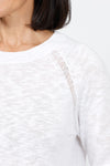 Metric Pointelle Crew Neck Sweater in White. Crew neck long sleeve sweater with raglan sleeves. Pointelle stitching at seams. Rib trim at neck, hem and cuff. Classic fit._t_35103948800200