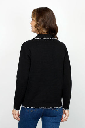 Metric 2 Tone Whipstitch Polo Sweater in Black.  Pointed collar with notched v neck pullover.  Long sleeves.  Dropped shoulders.  Ivory whipstitch around neckline, collar, cuff and hem.  Side slits.  Relaxed fit._61478426902894