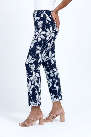 Holland ave Lilies Print Ankle Pant. White lily print on a midnight blue background. Pull on pant with 2 1/2" curved waistband. Snug through hip and thigh, falls straight to hem. 28" inseam._34888831074504