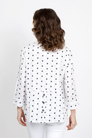 Habitat Dots Shirttail Top in White with embroidered black dots. Pointed collar button down with dropped waist seaming. Hidden front pocket with button. 3/4 sleeve with cuff. 3 button detail at lower back hem. High low hem. Relaxed fit._35420225962184
