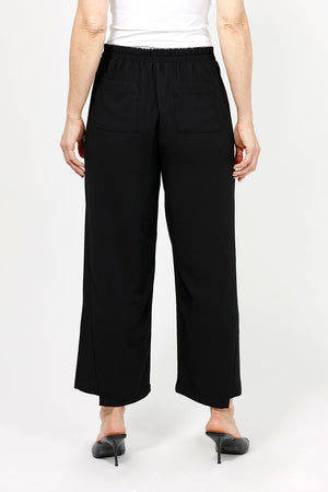 Lemon Grass Crop Pant with Button Detail. Pull on pant with 1 1/2" waistband elasticized in back. Faux front welt pocket detail. Draped leg. Side insets at hem create step hem. 3 button detail at hem. 25" inseam._35087786868936