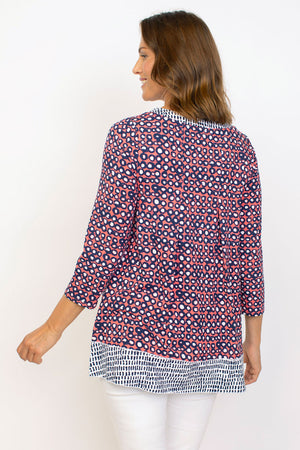 Habitat Travel Knit Pleat Back Tunic in Melon. Navy rimmed white dots on an orange background. Crew neck 3/4 sleeve a line top with complentary blue stick print on a white background. Pleat detail in back. Relaxed fit._35285596963016