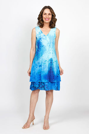 Top Ligne Watercolor Speckles Dress in Blue.  Speckled watercolor print in shades of blue.  Sleeveless v neck dress with 2 attached layers.  Bottom layer has attached ruffle at hem.  Top shorter layer.  Relaxed fit._35408815718600
