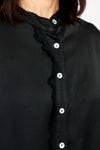 Lolo Luxe Washable Silk Button Down in Black.  Banded crew neck button down with 3/4 sleeve and cuff.  Fringed chiffon raw edge trim at right placket and on cuff.  High low hem.  Relaxed fit._t_61251999695214