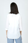 Elliott Lauren Embroider Me Shirt in White.  White pointed collar button down blouse with delicate sky blue floral and leaf embroidered motif on left side.  Long sleeve with button cuff.  Shirt tail high low hem with side inset.  Relaxed fit._t_60267567743342