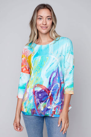 Claire Desjardins This Side of Home Curved Hem Top. Brightly colored garden print. Crew neck 3/4 sleeve top with drop shoulder. Curved hem. Relaxed fit._35071820595400