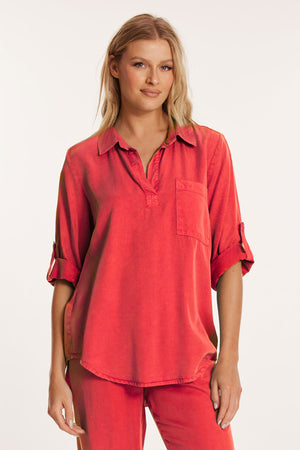 Mododoc Roll Tab Patch Pocket Tunic in Glazed Cherry . Pointed collar open placket popover top. 3/4 sleeve with roll tab. Single patch pocket. Curved high low hem. Relaxed fit._60189607952750