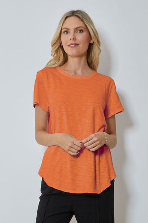 Mododoc Crew Neck High/Low Tee in Orange Clay. Crew neck tee with short sleeves. Curved high low hem. Relaxed fit._59880723677550