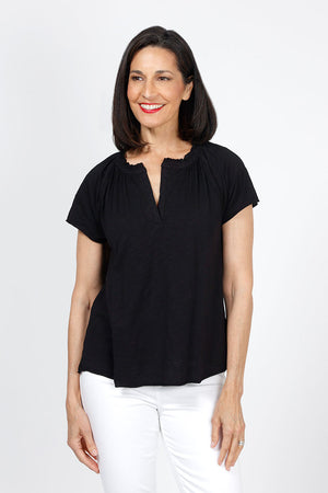 Mododoc Ruffle Henley Swing Tee in Black. Crew neck with open v placket. Raglan short sleeve. Ruffle at neck. Swing shape. Raw edges. Relaxed fit._35299706732744