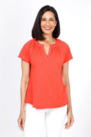 Mododoc Ruffle Henley Swing Tee in Fiery Tangerine. Crew neck with open v placket. Raglan short sleeve. Ruffle at neck. Swing shape. Raw edges. Relaxed fit._35299706831048