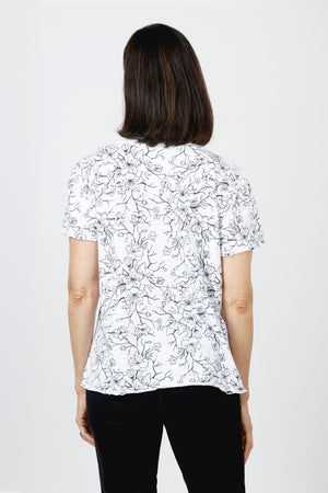 Mododoc Mixed Media Shirred Tee in White. Solid front with sketched black flower and vine pattern on sleeves and back.  Crew neck with short puffed sleeve.  Side seams wrap to front.  Raw edge at sleeve and hem.  High low hem. Relaxed fit._60036906615150