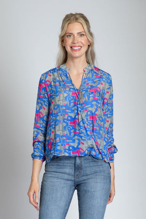 APNY Surplice Front Tassel Top.  Blue and gray abstract camo print with pink accents.  Banded crew neck with tassel ties.  Surplice front with hidden snap.  Gathered long sleeve with elastic cuff.  High low hem.  Relaxed fit._34808826134728