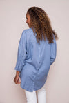 Suzy D Bonny Button Back Top in Jeans. Pointed collar split v shirt with center seam. Dolman 3/4 sleeve with button cuff. Soft side gathers. Back yoke with button detail down center back. High low hem. Slightly oversized fit._t_34225143349448