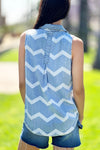 Billy T Myra Shirt in Denim with white chevron print. Sleeveless button down shirt with pointed collar. 2 front breast patch pockets. Center back placket with inverted pleat below. Shirt tail hem. Relaxed fit._t_34273372733640