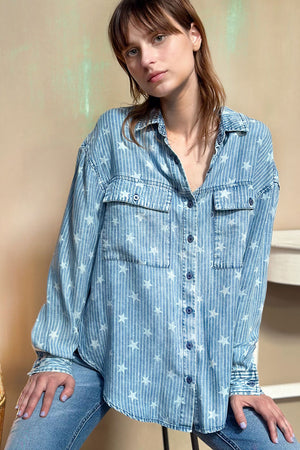 Billy T Stars & Stripes oversized Shirt in Denim.  Tone on tone denim striped top with all over stars print.  Pointed collar button down top with long sleeves.  Button cuffs and button roll tab.  2 front patch pockets with button flaps.  Back yoke.  High low hem.  Slouchy oversized fit._34277751161032