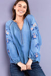 Billy T Cleo Embroidered Top in Denim.  Peasant style top.  Crew neck with split v placket.  Raglan 3/4 sleeve with elastic cuff.  Small floral embroidery around neckline, placket and raglan seams.  Large floral embroidery on sleeves.  Relaxed fit._t_35298644132040