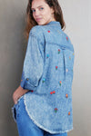 Billy T Wild Flower Embroidered Shirt in Denim. Pointed collar button down denim shirt with wildflower embroidery. Long sleeves with button cuff and roll button tab. Curved high low hem. Frayed hem. Back yoke. Relaxed fit._t_35298570862792