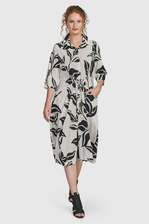 Alembika Botanica Business Dress.  Black lillies print on a beige background.  Pointed collar 3/4 sleeve dress with 1/2 button placket.  Cinch tie at waist.  Balloon skirt.  Relaxed fit._34778043187400