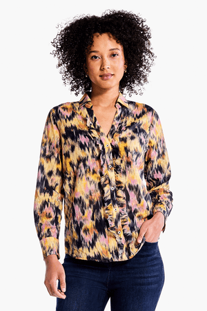 NIC+ZOE Dreamy Ruffle Shirt in Yellow Multi. Black, yellow and pink ikat inspired print. Pointed collar split v neck button down. Ruffle trim around button placket. Long sleeves with button cuffs. Back yoke. Shirt tail hem. Relaxed fit._34344705589448